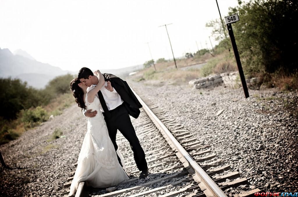 Пара обнимается на железнодорожных путях