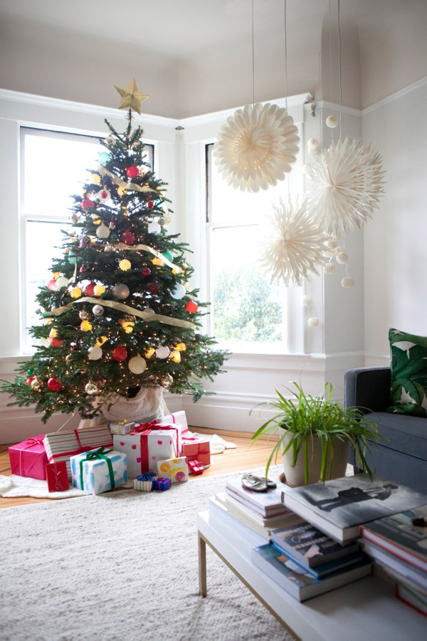 Новогодний декор в интерьере: украшенная ёлка, большие бумажные снежинки на окнах