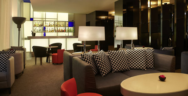 Бар Sofitel Hotel с удобными диванами и подушками с шахматным рисунком