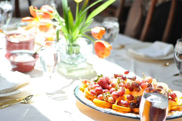 Тарелка с фруктами на сервированном обеденном столе