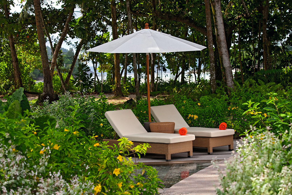 Лежаки под зонтом у отеля The Ephelia Resort на Сейшельских островах