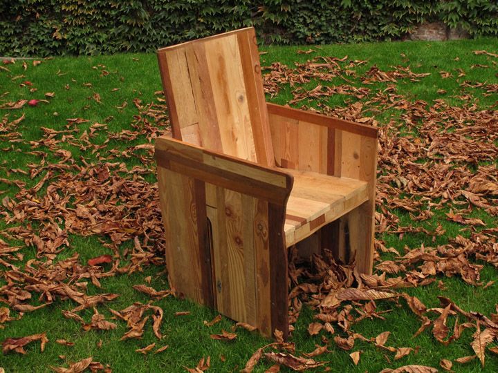 Кресло из дерева на газоне, усыпанном сухими листьями