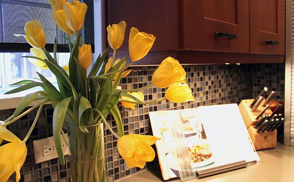 Кухонный щиток из красочной стеклянной мозаики и букет жёлтых тюльпанов
