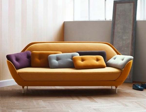Разноцветные подушки на мягком оранжевом диване