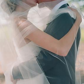 couple-under-wedding-veil-via-once-wed