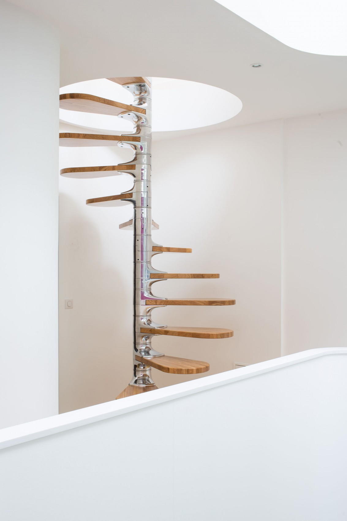 Винтовая лестница с деревянными ступенями в интерьере «Белого дома» в Ла-Рошели