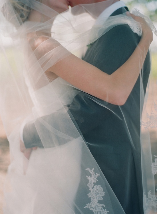couple-under-wedding-veil-via-once-wed